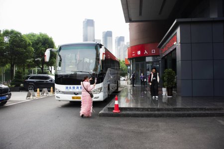Photo for Local modern buses stop waiting service send and receive chinese people and foreign travelers passengers journey go travel visit Zhangjiajie of Hunan at hotel in Yichang on May 7, 2024 in Hubei, China - Royalty Free Image