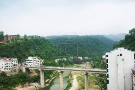 View landscape mountain forest and cityscape buildings house between chinese people drive ride vehicle journey on highway street from Yichang to Zhangjiajie of Hunan with traffic road in Hubei, China