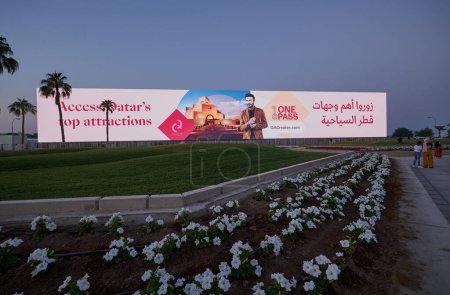 Foto de Doha corniche sunset view showing large outdoor screen promoting tourism in Qatar. Qatar preparación para la Copa Mundial de la FIFA 2022 - Imagen libre de derechos