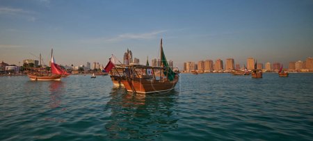 Téléchargez les photos : Katara12e festival traditionnel de boutre à Doha Qatar après-midi tournage montrant des boutres traditionnelles dans le golfe Arabe avec des drapeaux des pays de la Coupe du monde de la FIFA 2022 - en image libre de droit