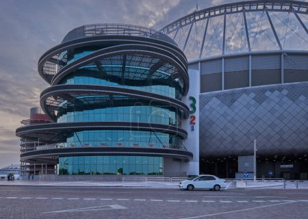 Foto de 3-2-1 Museo Olímpico y Deportivo de Qatar en Doha, Qatar Vista exterior del atardecer que muestra la arquitectura única de la construcción con nube en el cielo en el fondo - Imagen libre de derechos