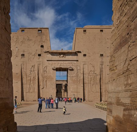 Téléchargez les photos : The Temple of Edfu  in Edfu, Egypt external daylight view showing main entrance with visitors and clouds in the sky in background - en image libre de droit