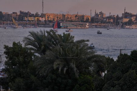 Photo for Luxor ,Egypt sunset shot from west bank showing Nile river with cruise ships , Feluccas and Winter palace hotel  in East bank - Royalty Free Image