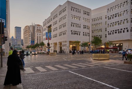 Téléchargez les photos : Msheireb Downtown Doha, Qatar après-midi photo montrant l'architecture unique des bâtiments avec des personnes et des voitures dans la rue - en image libre de droit