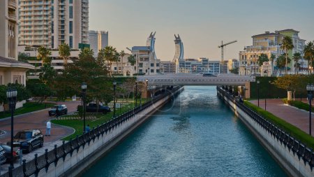 Téléchargez les photos : Doha, Qatar- Mars 1 2024 : Porto Arabia Marina dans La photo de l'après-midi perle montrant l'architecture unique des bâtiments avec des canaux d'eau, Yachts et les gens qui marchent - en image libre de droit