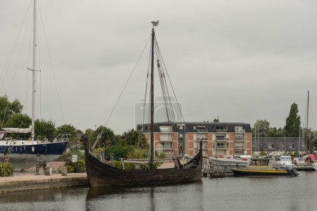 Téléchargez les photos : Drakkar, Viking wooden boat moored near a city. High quality photo - en image libre de droit