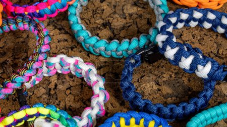 Photo for Braided paracord bracelets on a cork background. Handmade, creative design. - Royalty Free Image