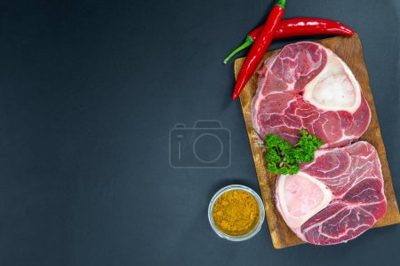 Téléchargez les photos : Biftecks de bœuf frais crus prêts à être grillés, tirés d'en haut. Condiments, légumes, fruits et herbes. - en image libre de droit