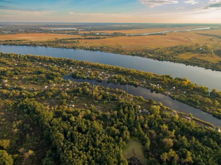 Téléchargez les photos : Vue aérienne de la rivière, de la forêt et des champs à la lumière du soleil levant. Région de Kherson, Kherson, Ukraine. - en image libre de droit