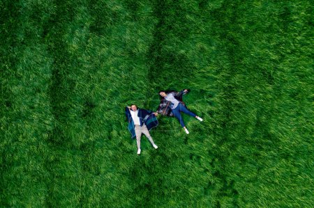 Téléchargez les photos : Un couple amoureux sur une grande prairie verte dans le parc. Vue de drone du bonheur et de la sérénité. - en image libre de droit