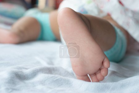 Nahaufnahme der weichen Füße des Babys auf der Matratze.