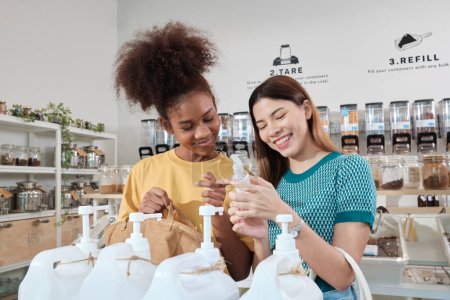 Photo for Two female customers are happy and enjoy shopping with natural organic products with recycled bottles at zero-waste and refill store, environment-friendly groceries, and sustainable lifestyles retail. - Royalty Free Image