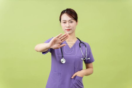Foto von jungen asiatischen weiblichen Arzt auf grünem Hintergrund