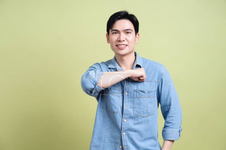 Foto von jungen asiatischen Mann auf grünem Hintergrund