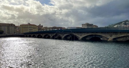 An old stone bridge crosses the river in the city of Pontevedra