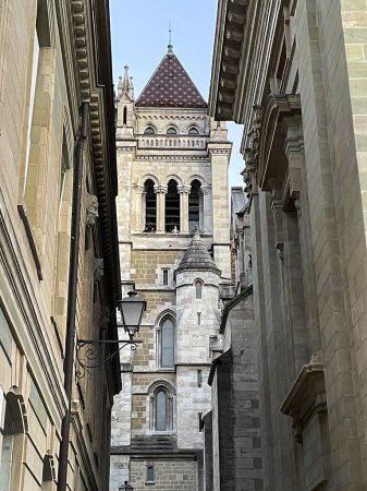 View of the tower of Cathedrale Saint-Pierre Geneve at the end of an alley in Geneva, Switzerland