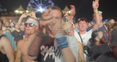 Photo for Joy on the face. Group of ravers huddle together in one area. Jumping people collide against each other, dancing visitors of electronic dance music event. CZ, Milovice, 6.8.22 Let it Roll - Royalty Free Image