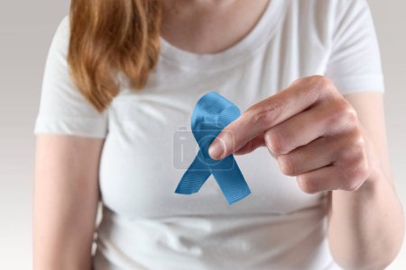 Téléchargez les photos : Jeune femme caucasienne tenant un ruban bleu de sensibilisation pour le mois de sensibilisation au cancer de la prostate. - en image libre de droit