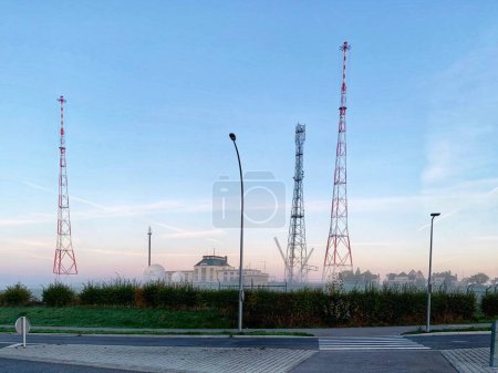Foto de Junglinster Longwave Transmisor - tres torres de marco metálico de 215 m de altura en la niebla de la mañana temprano, y SES instalación de teletransporte con antenas parabólicas - Imagen libre de derechos