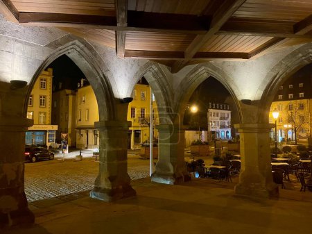 Foto de Ayuntamiento medieval de Echternach por la noche. Vista desde el interior de arcos en planta baja hacia Plaza del Mercado. Echternach, Luxemburgo - 9 de noviembre de 2022 - Imagen libre de derechos