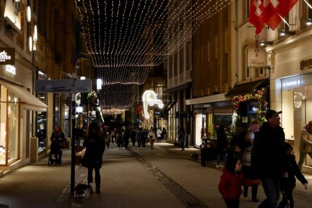 Photo for Christmas decorations and crowds of people walking on the street at night in Luxembourg, Luxembourg - December 27, 2022 - Royalty Free Image