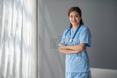 Téléchargez les photos : Portrait de femme asiatique médecin debout dans son bureau à la clinique... - en image libre de droit