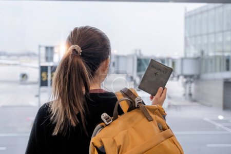 Foto de Viajero con pasaporte y tarjetas de embarque esperando para ser transferido de una terminal a otra Vuelo de conexión en el aeropuerto. - Imagen libre de derechos