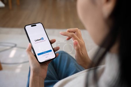 Photo for CHIANG MAI, THAILAND, FEB 27,2024 : A women holds Apple iPhone 14 Pro Max with LinkedIn application on the screen.LinkedIn is a photo-sharing app for smartphones.. - Royalty Free Image