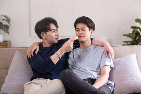 Photo for A male-male couple spends their free time happily doing holiday activities together, embracing each other and taking selfies together in the living room.. - Royalty Free Image