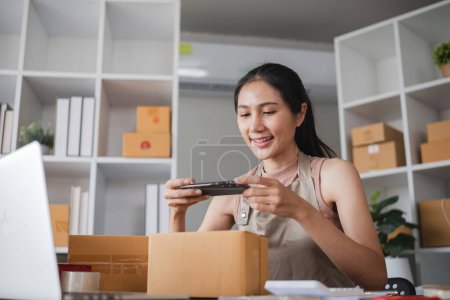 Businesswoman taking photos of products for online store in office. Concept of e-commerce and product photography.