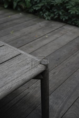 Table neutre grise à l'extérieur sur plancher organique en bois design esthétique.