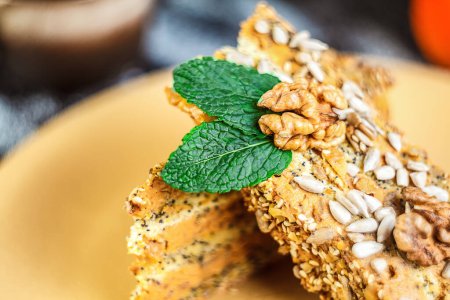 Photo for A hearty and healthy walnut cake, sprinkled with fresh herbs and mint seeds for a delicious dessert or meal. - Royalty Free Image