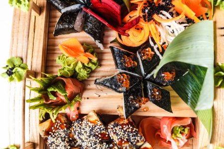 Photo for A colorful set of fresh sushi rolls, vegetables and other healthy dishes fill the plate - a perfect meal for wellbeing. - Royalty Free Image