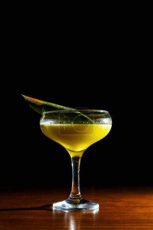 Photo for A vibrant, yellow cocktail sits invitingly in a glass indoors - an alcoholic refreshment perfect for any occasion. - Royalty Free Image