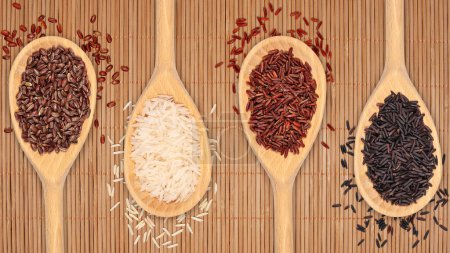 Téléchargez les photos : Quatre cuillères en bois représentent différents types de riz : Basmati, Wild, Unpolished et Brown. La gamme représente différents grains utilisés dans la cuisine internationale. - en image libre de droit