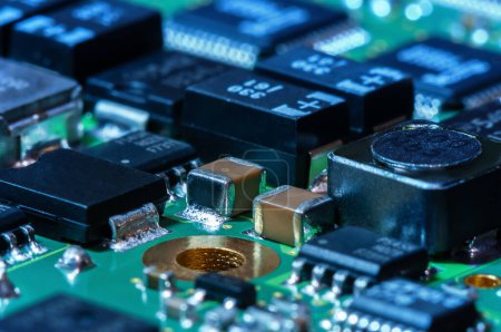 Primer plano de la placa de circuito impreso con procesador, circuitos integrados y muchos otros componentes eléctricos pasivos montados en la superficie.