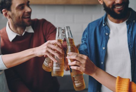 Foto de Primer plano de jóvenes felices brindando con cerveza mientras pasan un tiempo divertido juntos - Imagen libre de derechos