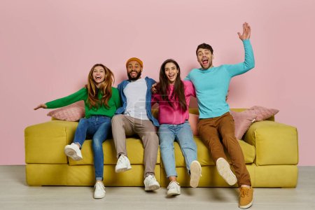 Téléchargez les photos : Plan studio de jeunes gens heureux embrassant et sautant sur le canapé ensemble - en image libre de droit