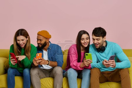 Foto de Captura de estudio de jóvenes usando teléfonos inteligentes y comunicándose mientras están sentados en el sofá juntos - Imagen libre de derechos