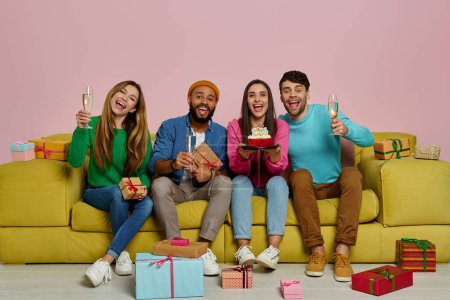 Photo for Young people celebrating birthday while sitting on the couch against pink background - Royalty Free Image