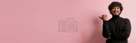 Foto de Hombre indio guapo apuntando espacio de copia y sonriendo sobre fondo rosa - Imagen libre de derechos