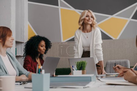 Photo for Group of mature women discussing business while having meeting in the office - Royalty Free Image