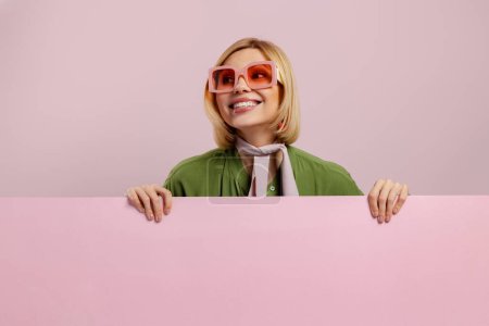 Foto de Estudio de la foto de la mujer joven de moda mirando fuera del espacio de copia rosa y sonriendo - Imagen libre de derechos