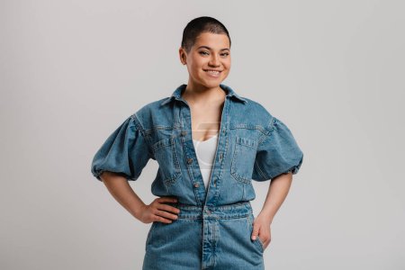 Photo for Beautiful young short hair woman in denim clothes looking at camera against grey background - Royalty Free Image