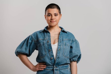 Photo for Beautiful young short hair woman in denim clothes looking at camera against grey background - Royalty Free Image