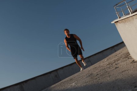 Téléchargez les photos : Jeune homme confiant en vêtements de sport profitant du jogging matinal en plein air - en image libre de droit