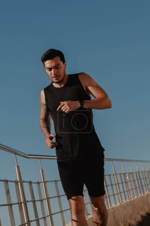 Photo for Handsome male athlete in sportswear running downstairs while training outdoors - Royalty Free Image