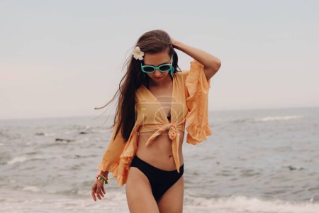 Téléchargez les photos : Belle jeune femme dans boho style crop top profiter de la journée d'été sur la plage - en image libre de droit