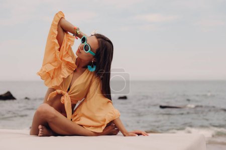 Photo for Beautiful young woman in boho styled crop top enjoying summer day seaside - Royalty Free Image