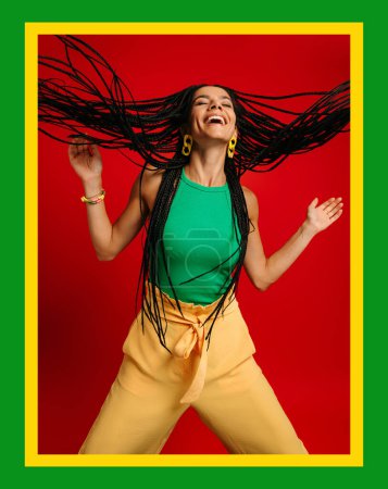 Photo for Happy young Hispanic woman with dreadlocs dancing against red background - Royalty Free Image